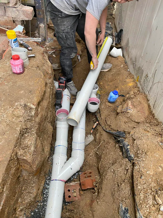 New drainage pipework laid and jointed in an open trench